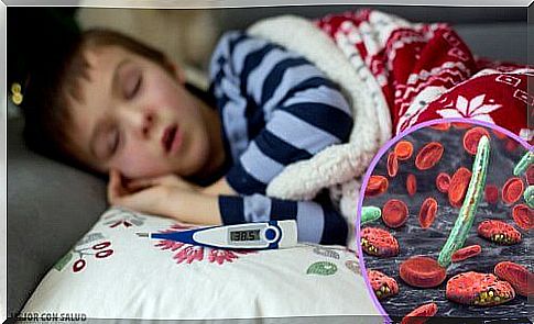 Sleeping boy with a thermometer indicating that he has a fever.