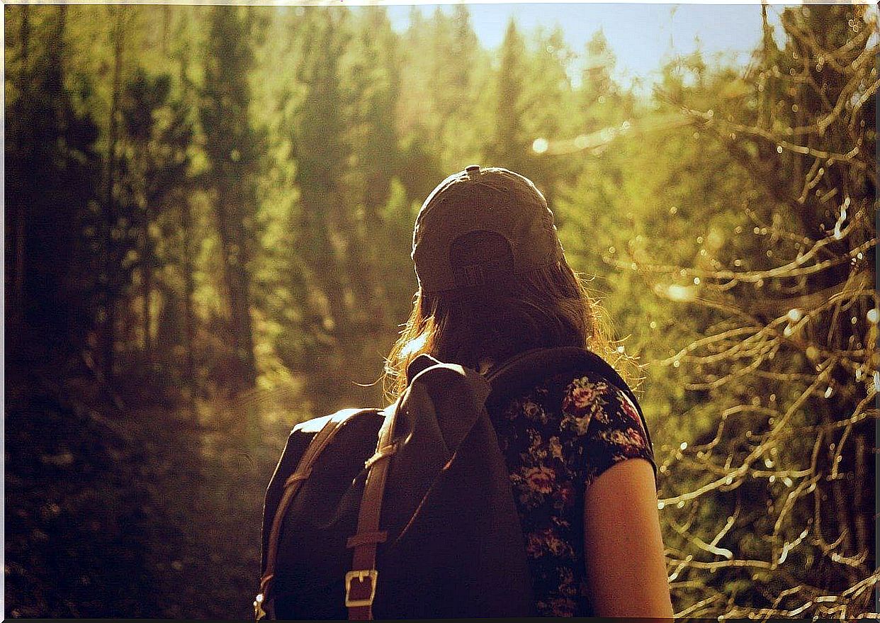 Woman with backpack in the forest.