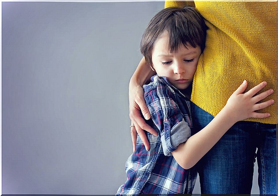 Child hugging his mother in fear.