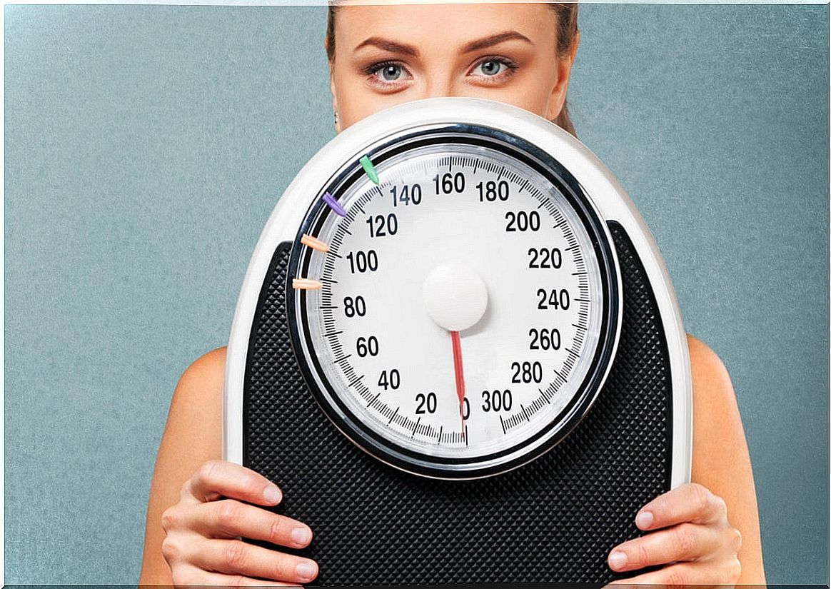 Woman with scale measuring Sirtfood diet.