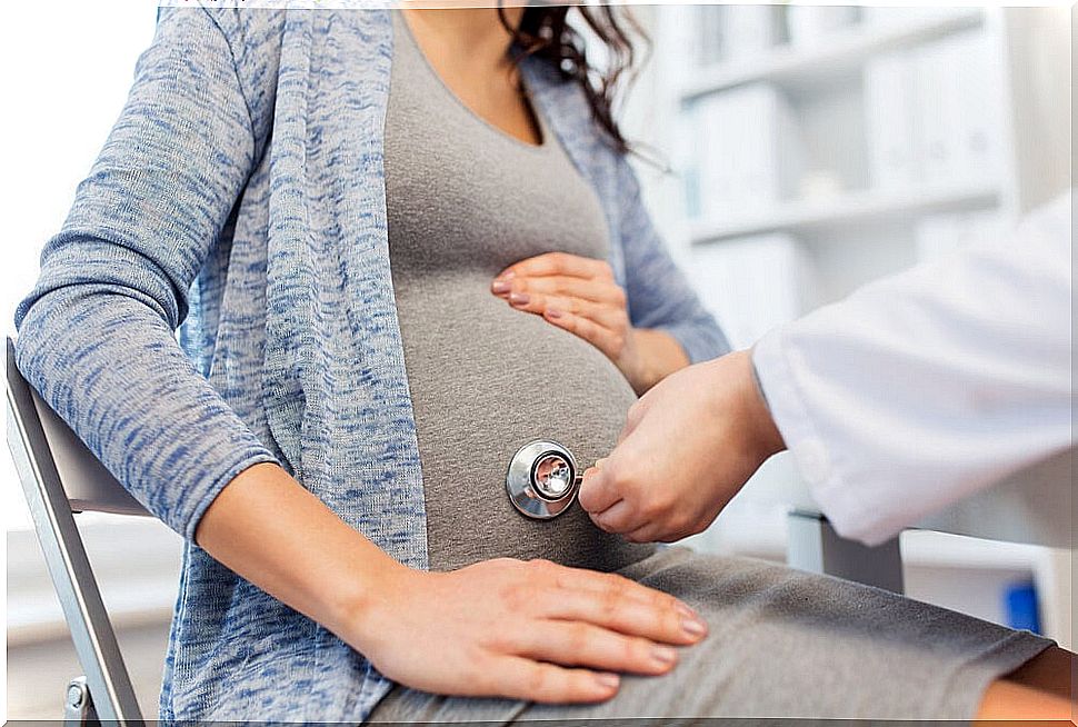 Pregnant woman being monitored by a doctor.