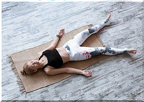 Woman on yoga blanket, in soldier pose.